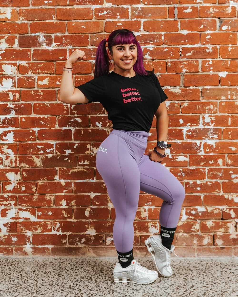 Romina flexing against the red brick wall at Project Better Collingwood